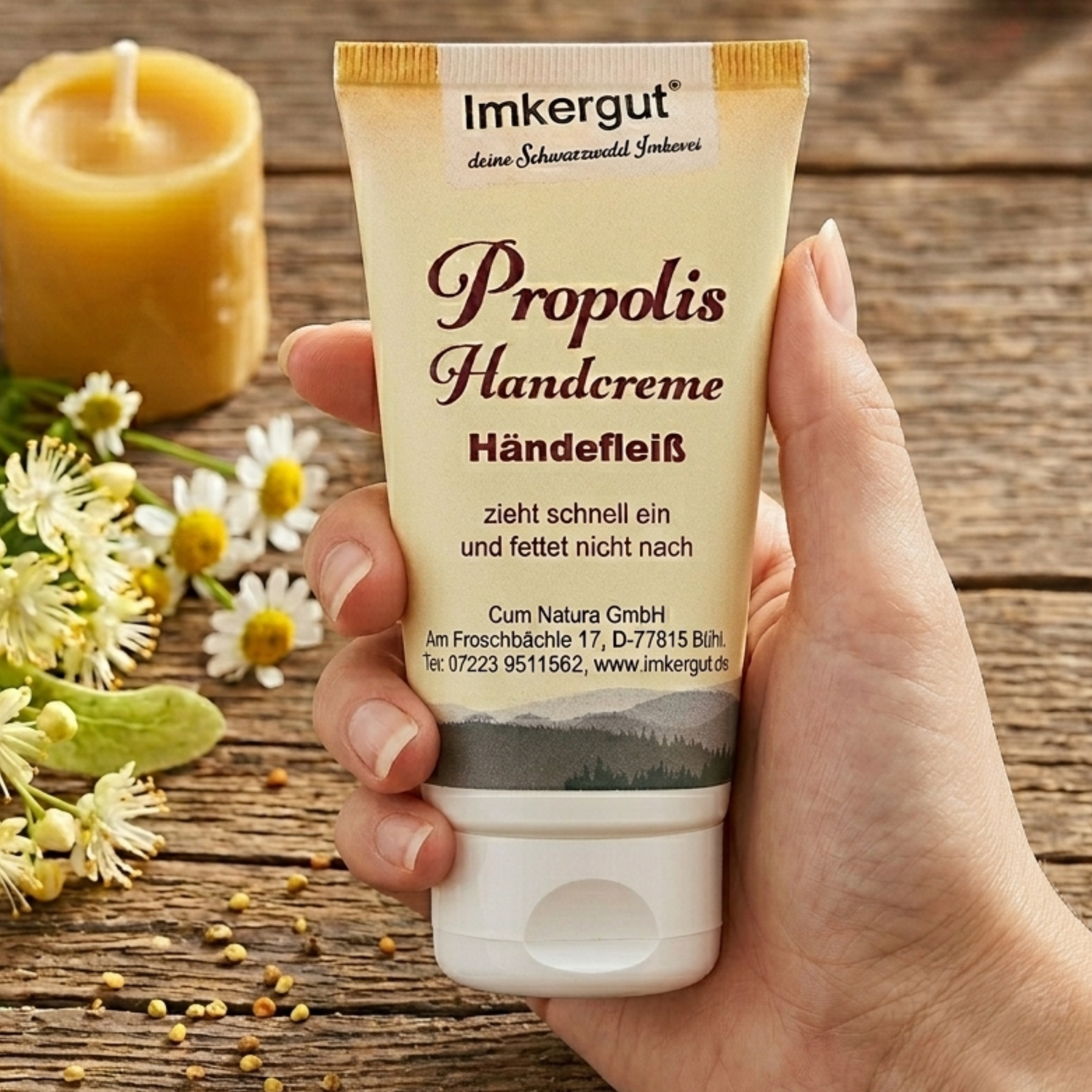 Propolis-Handcreme, die in einer Damenhand in das Bild gehalten wird