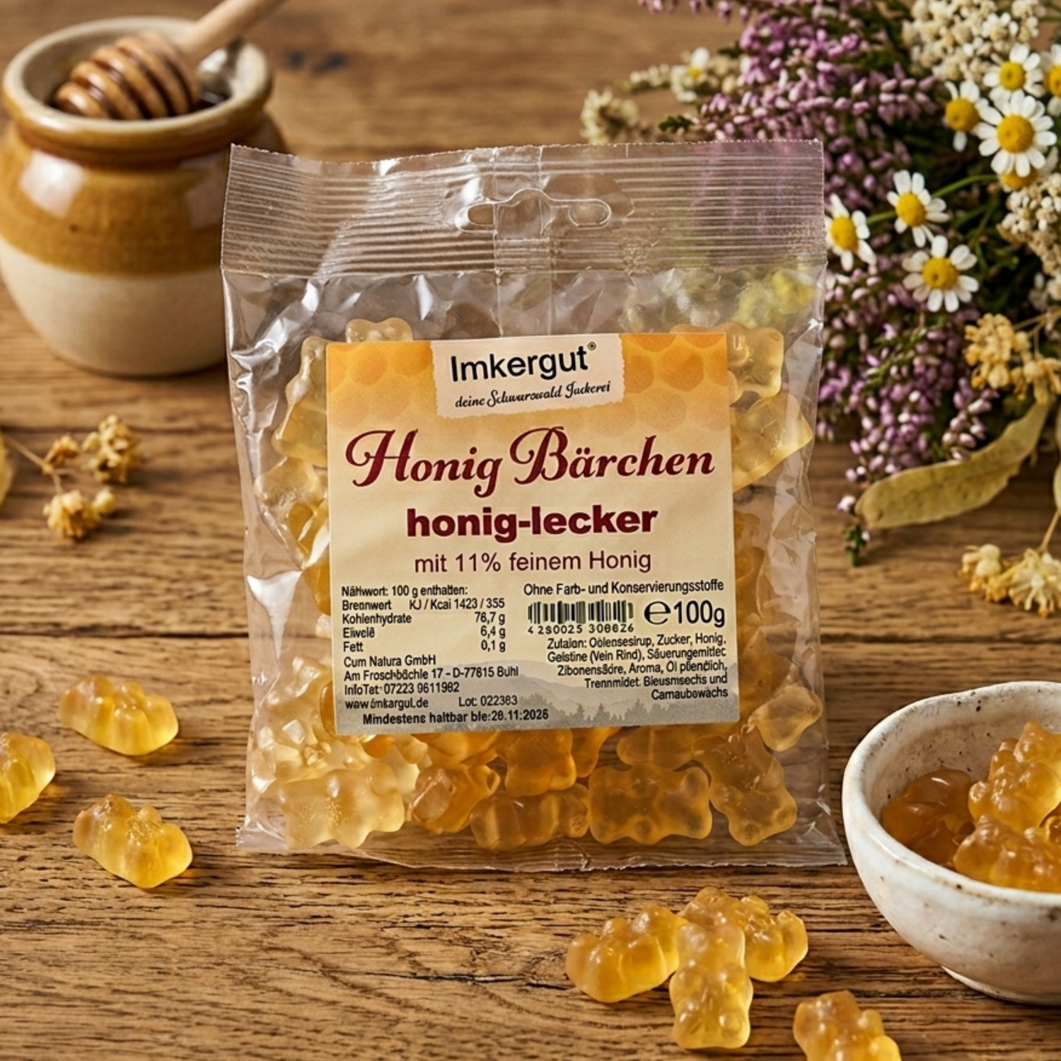 Honig-Bärchen auf einem Holztisch, daneben eine kleine Schale mit Honig-Bärchen von der Imkerei Ostermann