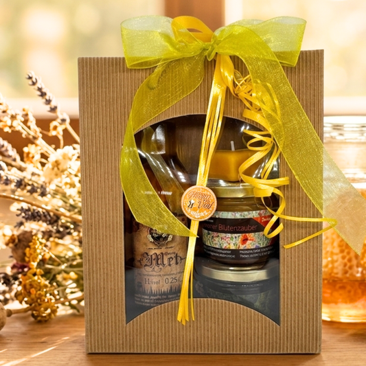 Geschenkset von der Familienimkerei Ostermann: Honig Met, handgegossene Bienenwachskerze in Herzform, je 150g Waldhonig und Blütenhonig in einer Geschenkverpackung mit Schleife und Grußanhänger.