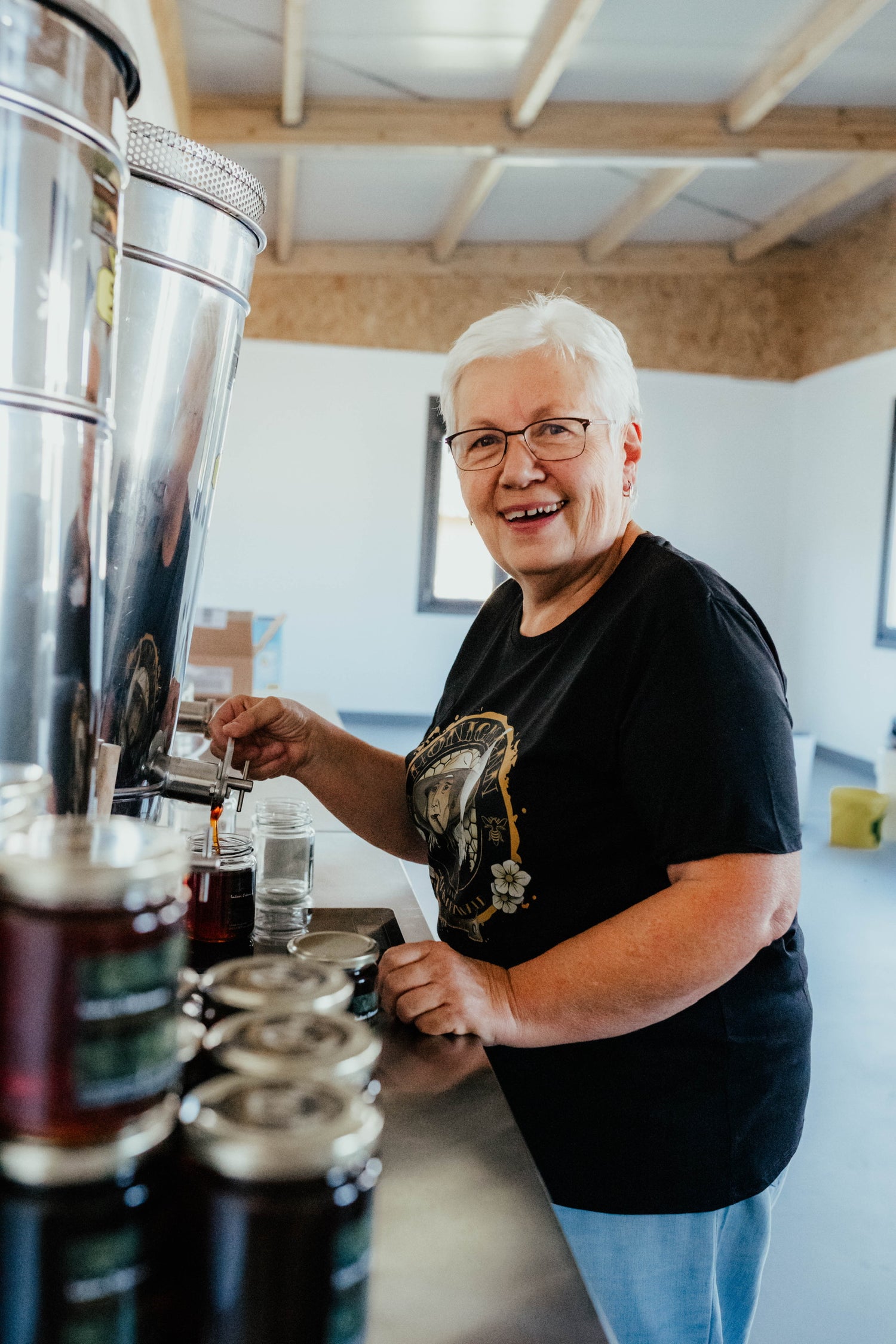 Ute Ostermann bei der handwerklichen Abfüllung und Etikettierung von Honiggläsern in der Imkerei.